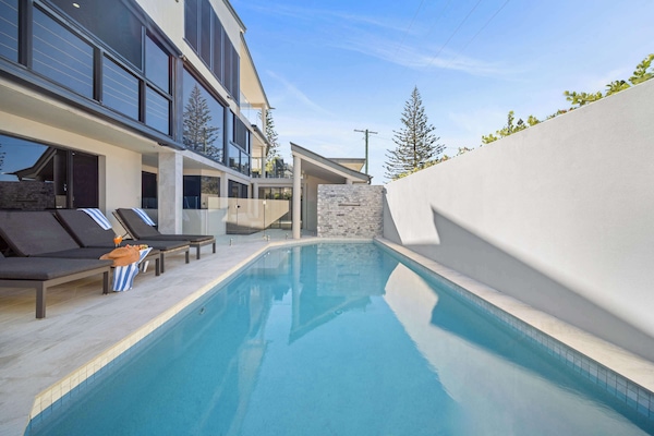 Sparkling outdoor pool with sun loungers, perfect for relaxing under the sun.