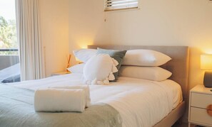 Enjoy a restful stay in this cozy hotel room featuring a comfortable bed, bedside table, and balcony access.