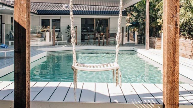 A wooden swing with ropes, a swimming pool, and a covered patio area. - Prime location with pool - walk to Coolum Beach (Coolum Region)