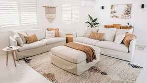 A living room with a sectional sofa, a coffee table, and a side table. - Prime location with pool - walk to Coolum Beach (Coolum Region)