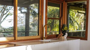 Una cocina moderna con un ventanal grande, un lavamanos y un bloque de cuchillos.