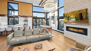 Una sala de estar moderna con chimenea, comedor y cocina.