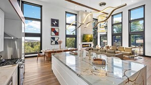 A spacious kitchen with a large island, a fireplace, and a dining area with a view.