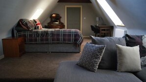 A cozy attic bedroom with a bed, a sofa, and a small table. - Georgianstyle-2bed-smarttv-freeparking (Boston)
