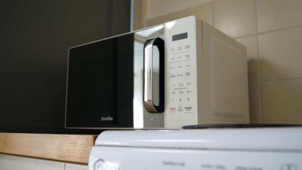 A microwave with a digital display and control panel, placed on a kitchen counter. - Georgianstyle-2bed-smarttv-freeparking (Boston)