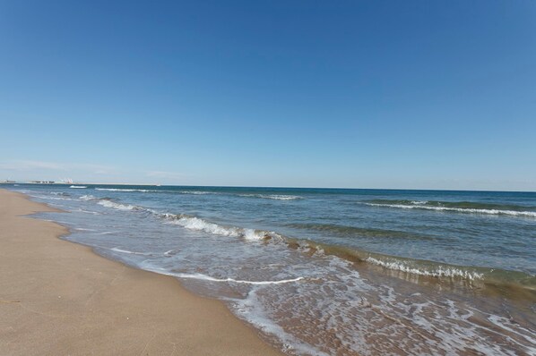 Une plage avec un ciel dégagé et des vagues douces.