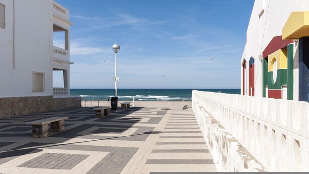 A coastal promenade with a clear view of the sea, benches, and a lamp post. - Comtessa in Oliva With 1 Bedrooms and 1 Bathrooms (Oliva)