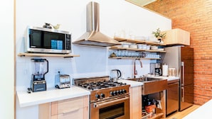 A compact kitchen with a microwave, stove, oven, and a refrigerator. - Retro Vibe,  downtown Grand Forks (Grand Forks)