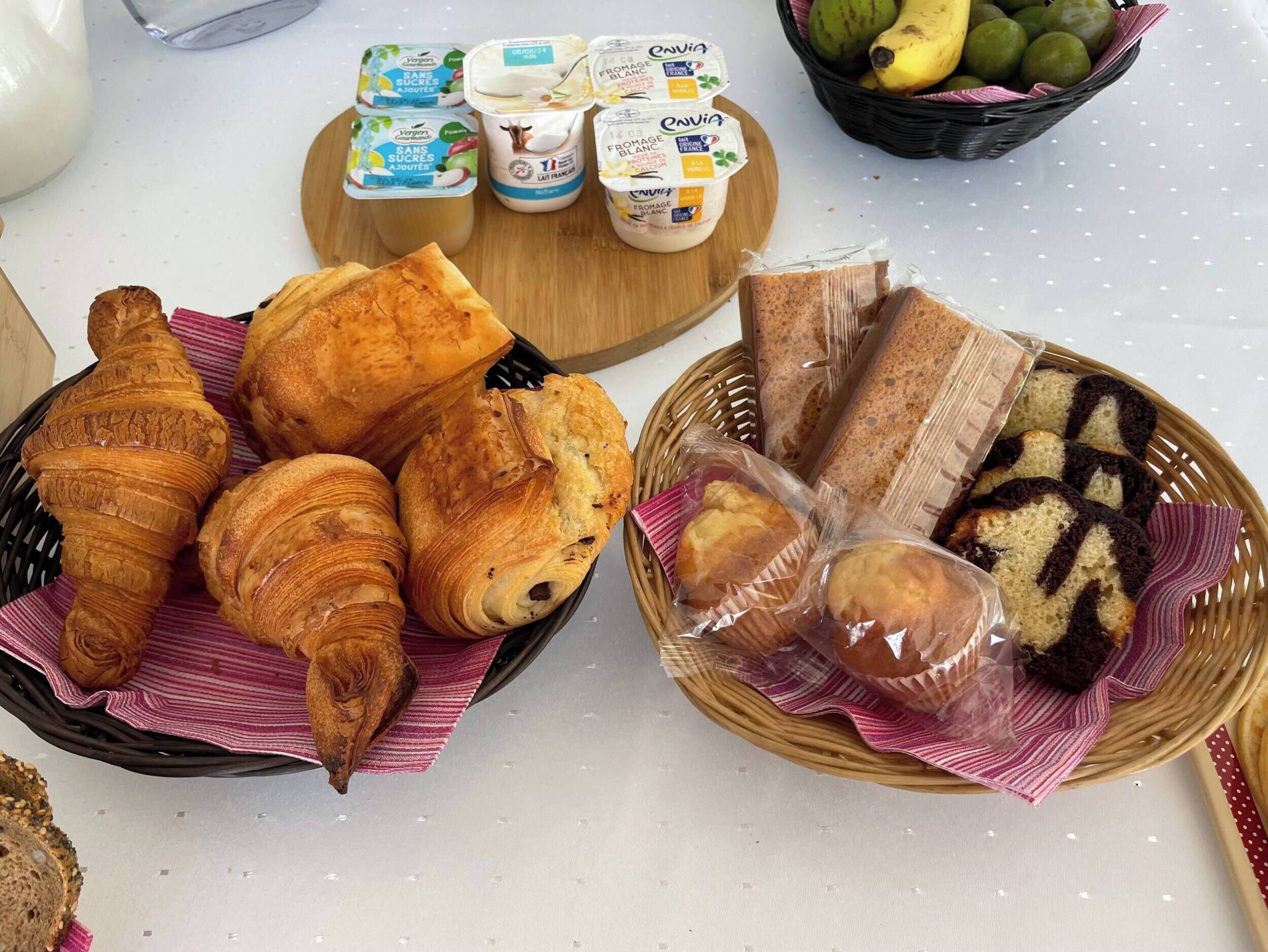 A table with pastries, bread, and dairy products.