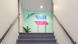 Een trap met een bord waarop staat: welkom bij Stay Suites.