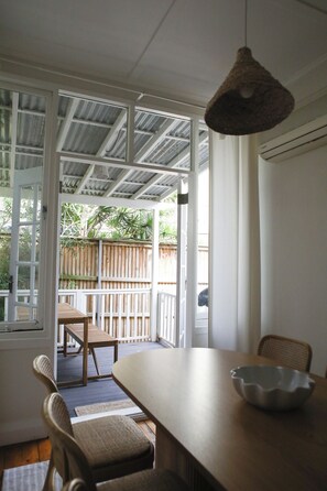 Enjoy meals at the dining table with a view of the outdoor area through the sliding glass door.