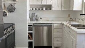 A kitchen with white cabinets, a stainless steel dishwasher, and a black oven. - This house is a 2 bedroom(s), 1 bathrooms, located in Nashville, TN. (Nashville)