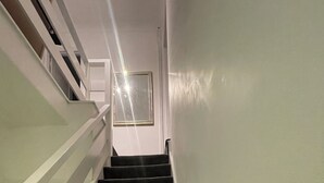 A staircase with carpeted steps and white walls.