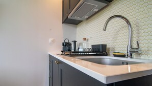 A kitchen with a stainless steel sink, a coffee maker, and a kettle on the countertop. - Amélia - Apartment 3★ - 4 pers - Near Etretat - Parking - High Speed Wifi (La Poterie-Cap-d'Antifer)
