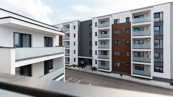 Un edificio residencial moderno de varios pisos con balcones y cielo despejado.
