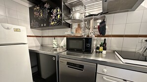 Eine moderne Küche mit Edelstahlgeräten, darunter ein Kühlschrank, eine Spülmaschine, eine Mikrowelle und ein Backofen.
