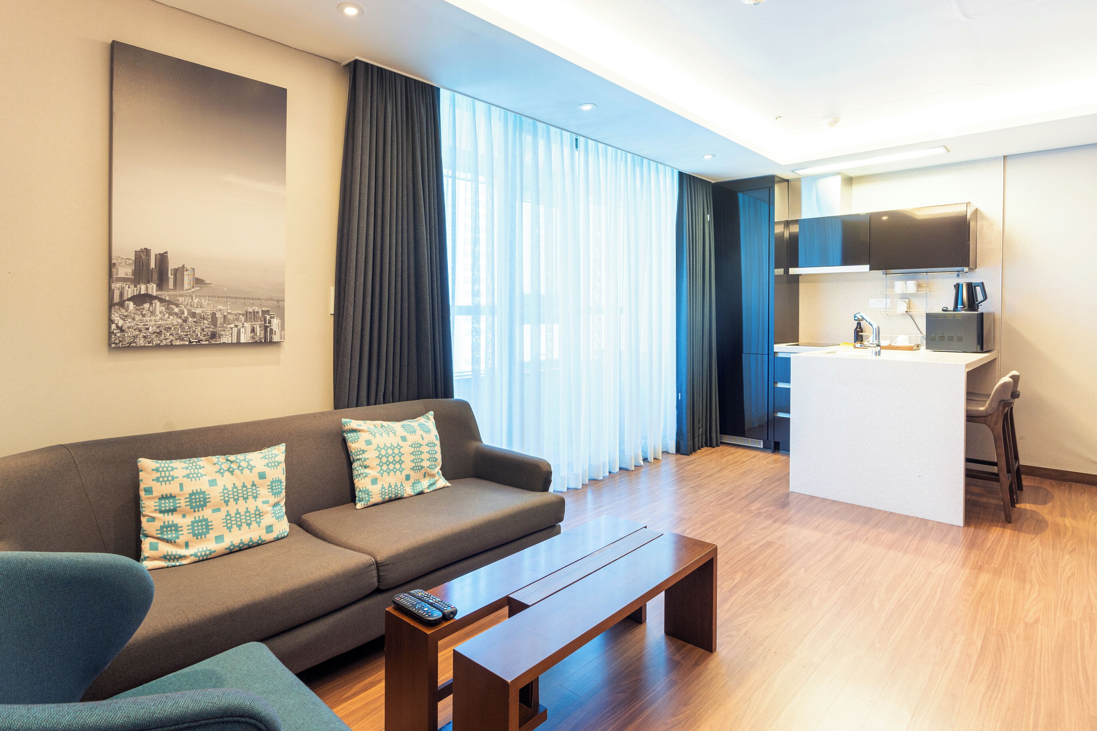 Una sala de estar moderna con un sofá, una mesa de centro y un control remoto.