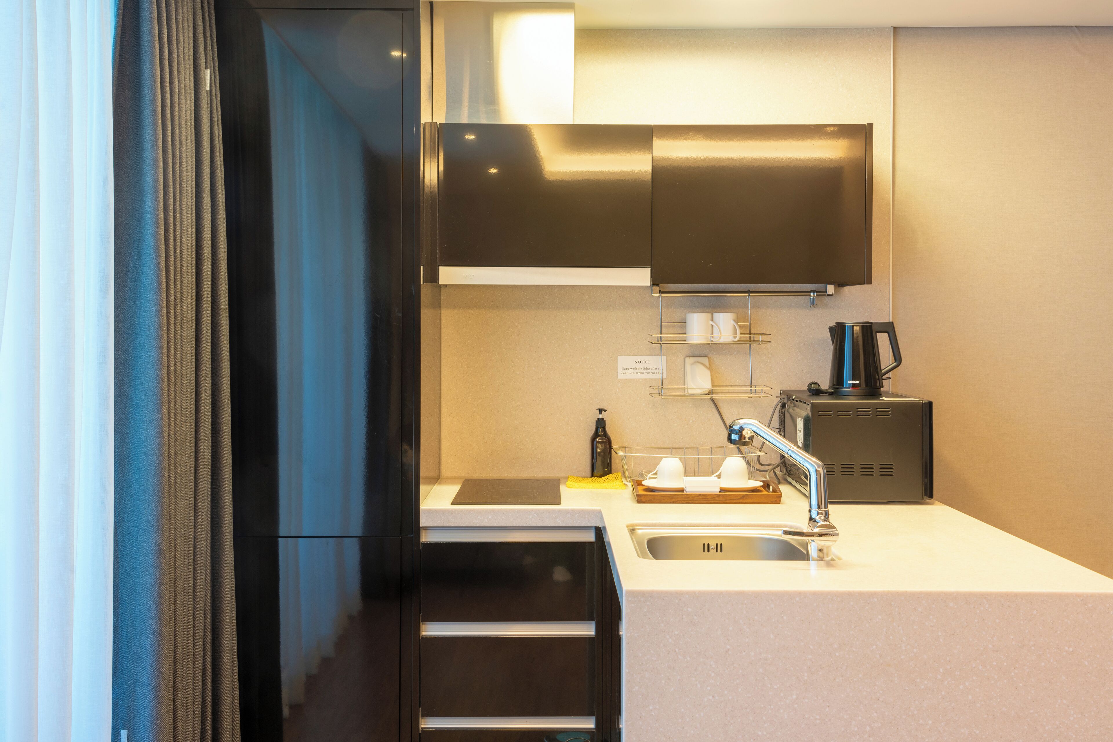 A modern kitchen with stainless steel appliances, a built-in oven, and a coffee machine.
