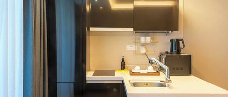 A modern kitchen with stainless steel appliances, a built-in oven, and a coffee machine.