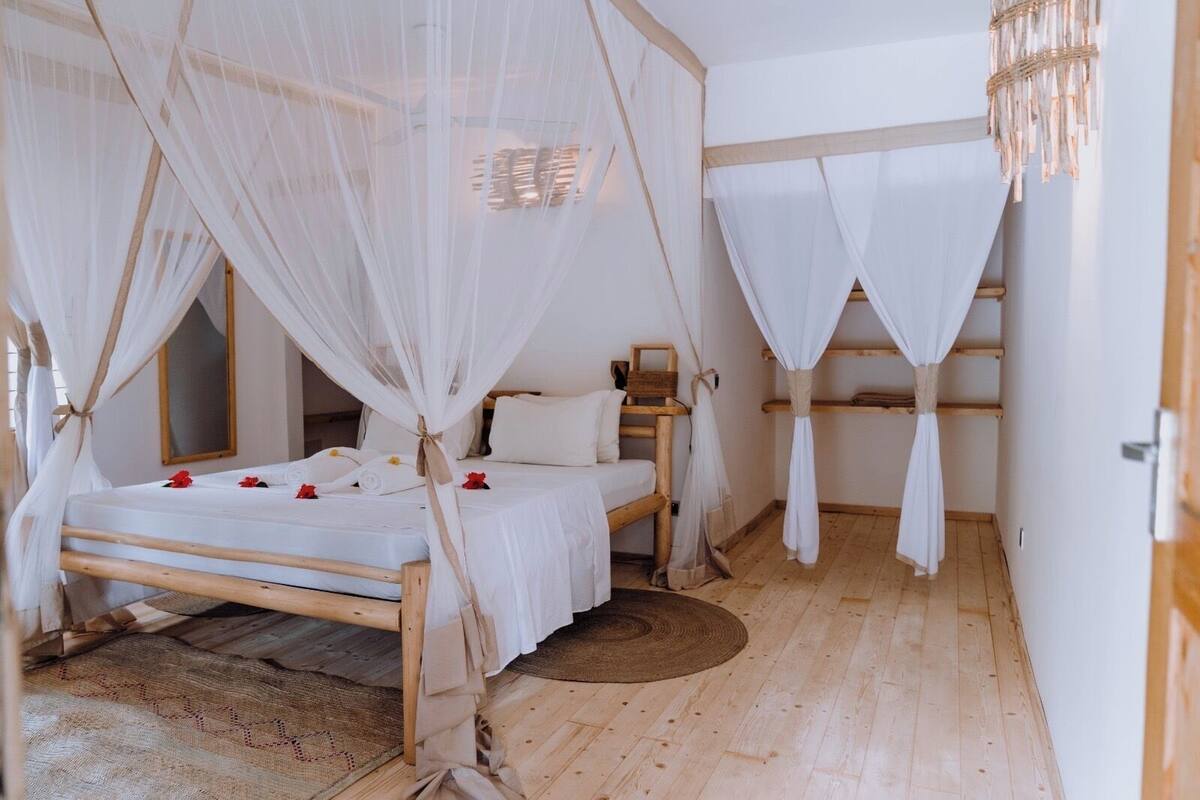 Ein Zimmer mit einem Bett, einem Nachttisch und Holzboden.