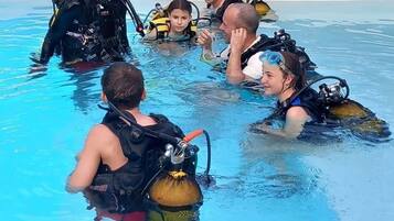 Una piscina al aire libre, sombrillas, sillones reclinables de piscina