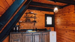 A rustic cabin interior with a wooden interior, a kitchen area with a sink and cabinets, and a window with blinds. - Sapanca Saklı Bungalov (Sapanca)