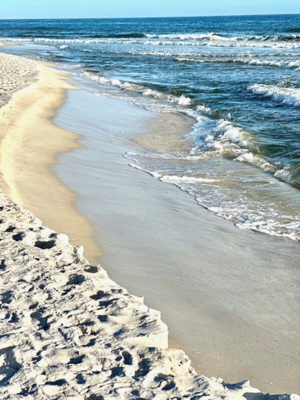 Ein Strand mit sandigem Ufer und Wellen.