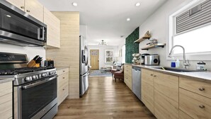 A modern kitchen with stainless steel appliances, wooden cabinets, and a central island.