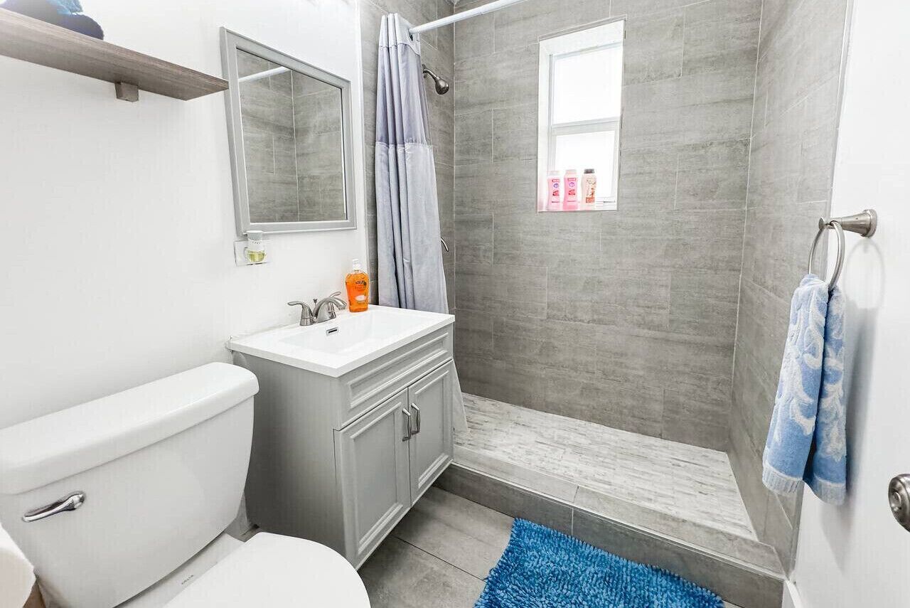 Un baño con inodoro, lavabo y zona de ducha.