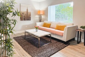 Un salon moderne avec un canapé, une table basse et une lampe.