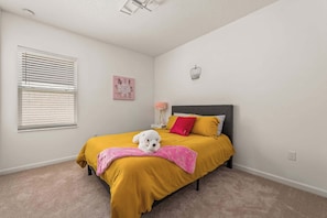 Un dormitorio con cama, ventana, decoración en la pared y luz en el techo.