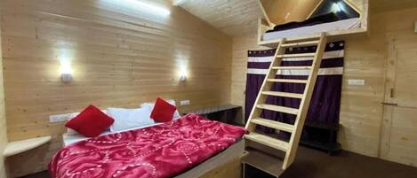 Una camera compatta con un letto a castello, una scala e una piccola scrivania.