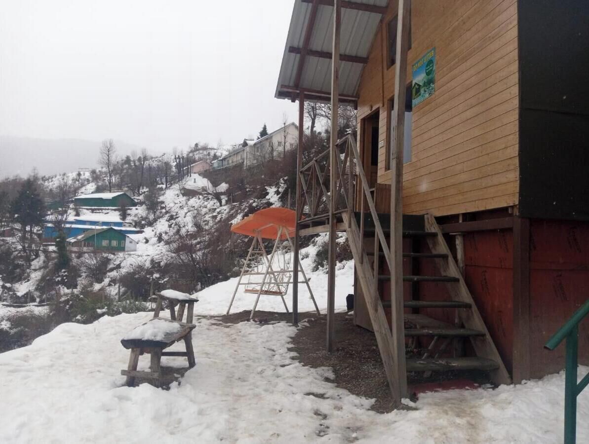 Un edificio de madera con una escalera que lleva a un espacio cubierto.