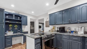 A modern kitchen with dark cabinets, granite countertops, and stainless steel appliances. - Fox Creek Hideaway | Marcel Stays (Belleville)