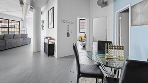 Un espacio habitable moderno y abierto, con una mesa de comedor de vidrio, un sofá y una decoración minimalista.