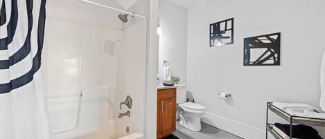 A modern bathroom with a walk-in shower, a toilet, and a sink.