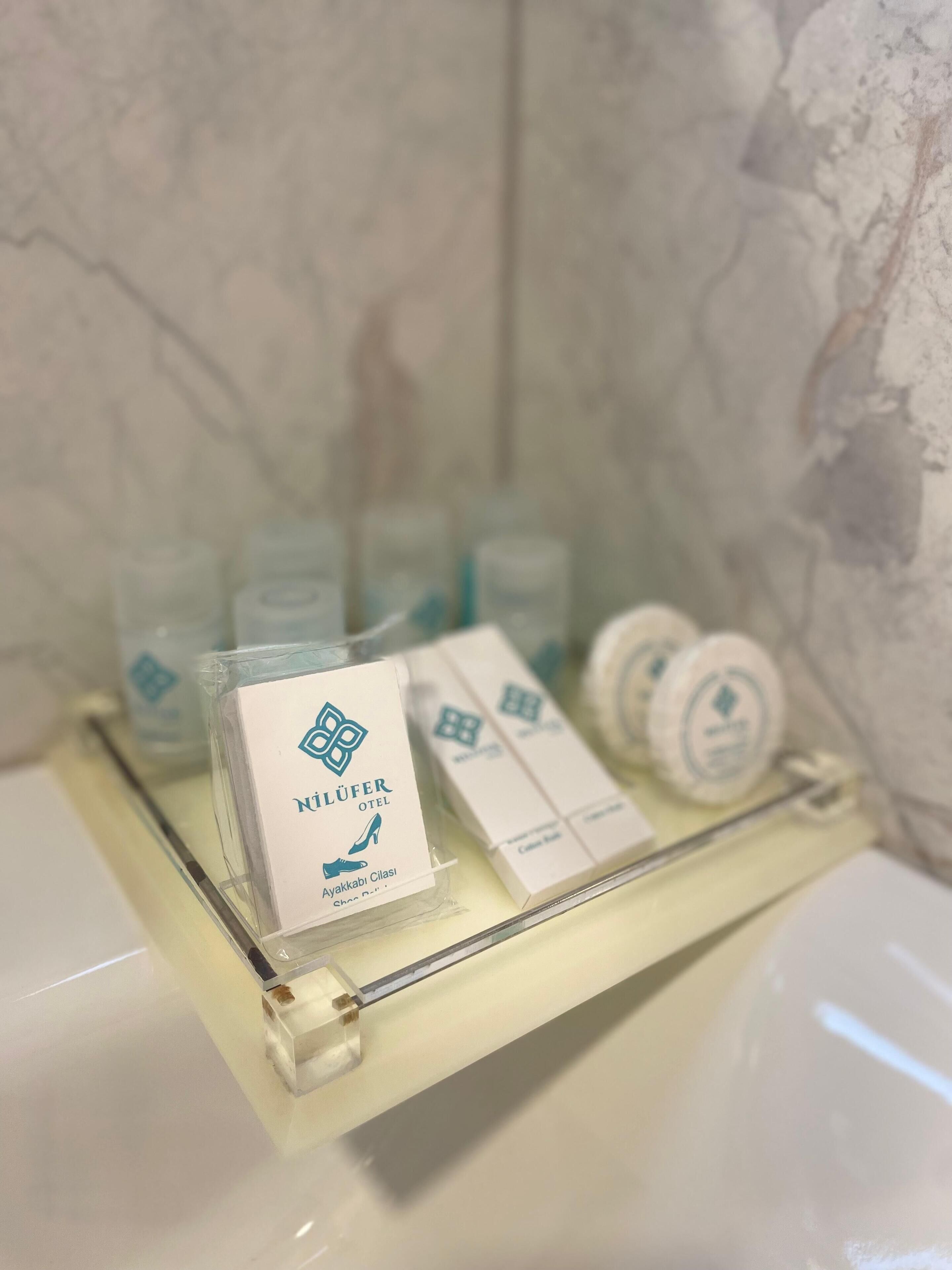 A bathroom counter with toiletries including a shoe care kit, a toothbrush, and a soap dispenser.