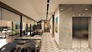 A modern interior with a long corridor, seating area with tables and chairs, and an elevator. - By otel Nilüfer  (Bursa)