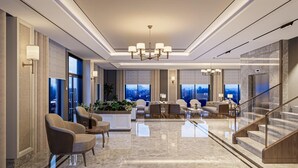 A spacious lobby with a high ceiling, modern chandeliers, and a seating area with sofas and armchairs. - By otel Nilüfer  (Bursa)