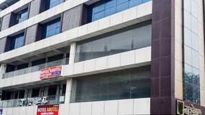 Un edificio de varios pisos con letreros que indican 'HOTEL AROTEL' y 'ACINHO AC ROOM'.