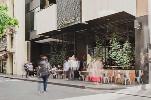 A restaurant with outdoor seating, a modern facade, and a sign that reads 'Brunetti.'