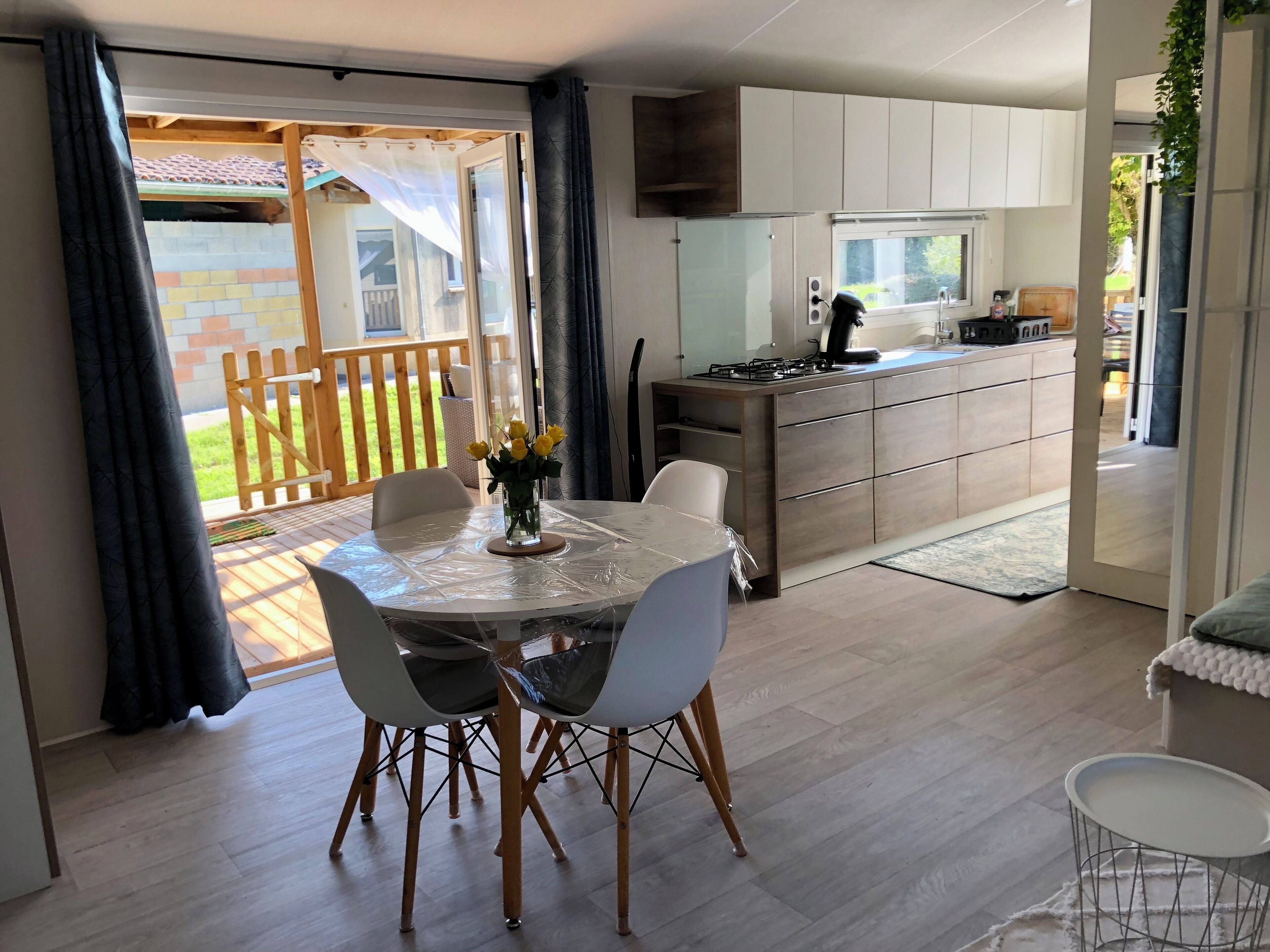 Una cocina moderna con estufa a gas, un lavabo y una zona de comedor con una mesa redonda y sillas.