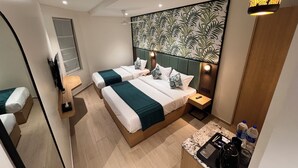 A modern hotel room with two beds, a small kitchenette, a large window, and a decorative wall panel. - Esquire Hotel Mumbai (Mumbai)