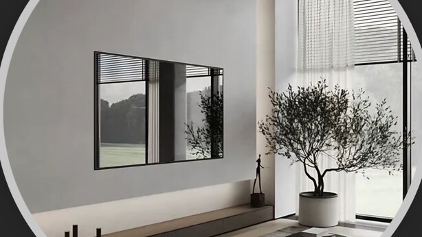 Un salón moderno con diseño minimalista, que cuenta con un amplio ventanal, un árbol en maceta y una obra de arte con marco negro en la pared.