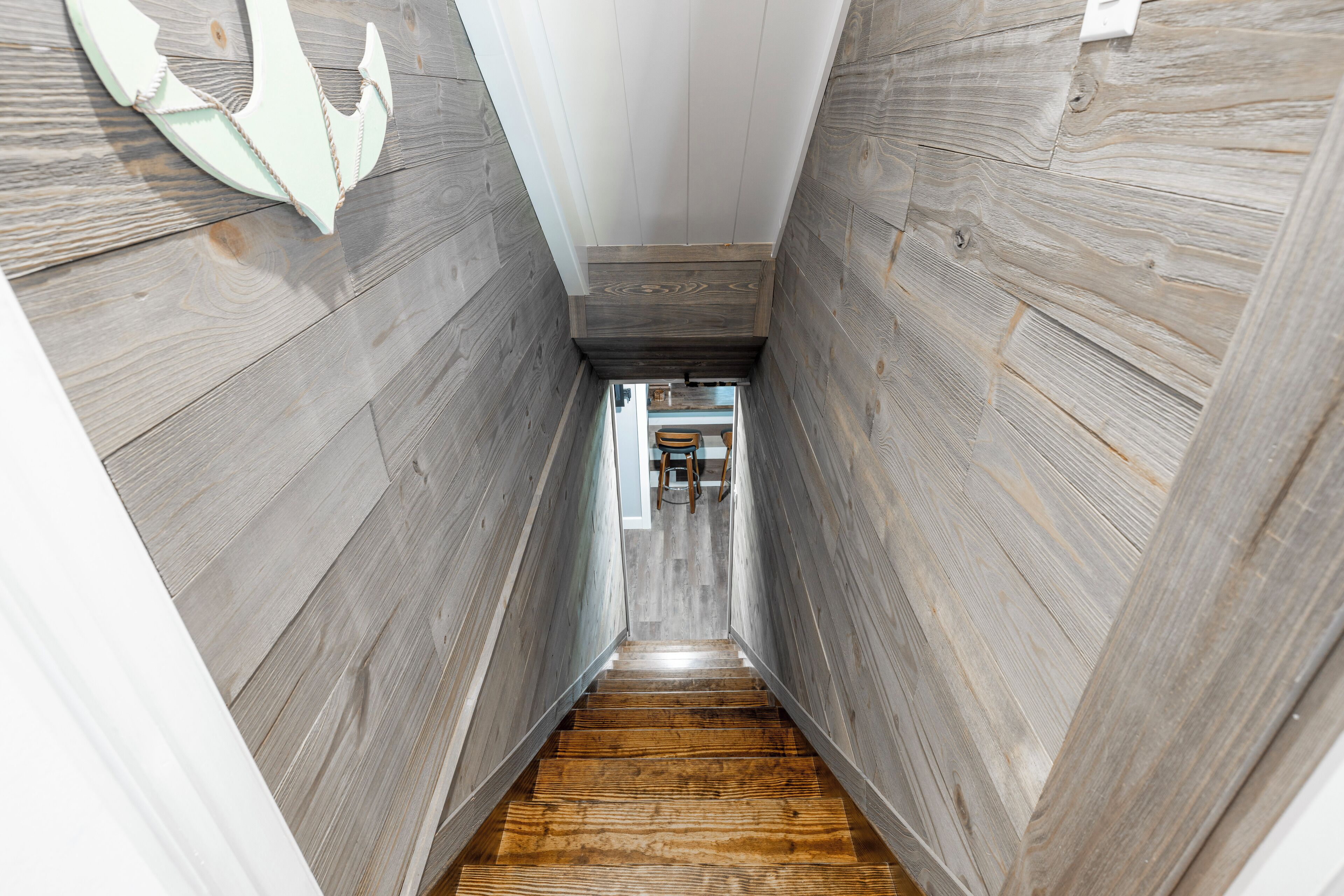 Una escalera de madera estrecha que da a una habitación en la parte superior.