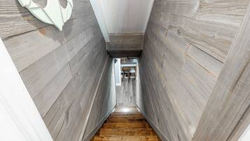 Una escalera de madera estrecha que da a una habitación en la parte superior.