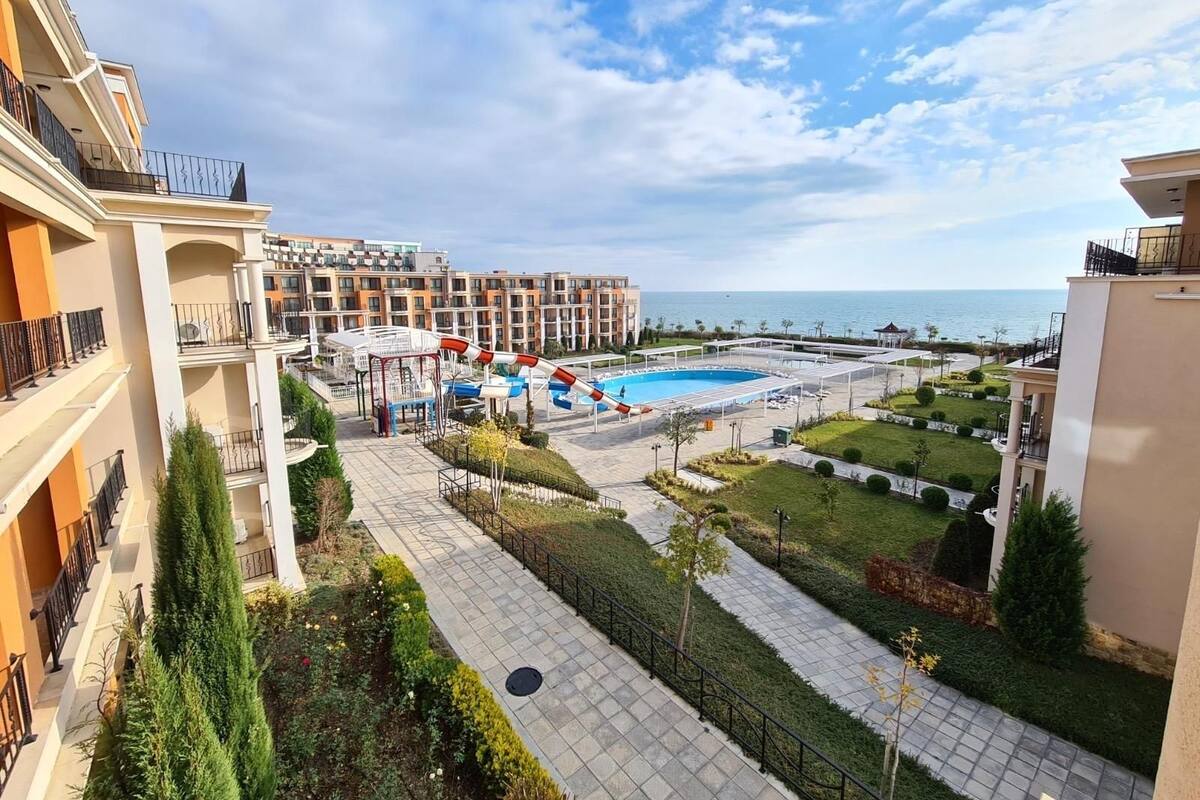 A hotel with a swimming pool, a children's play area, and a view of the sea.