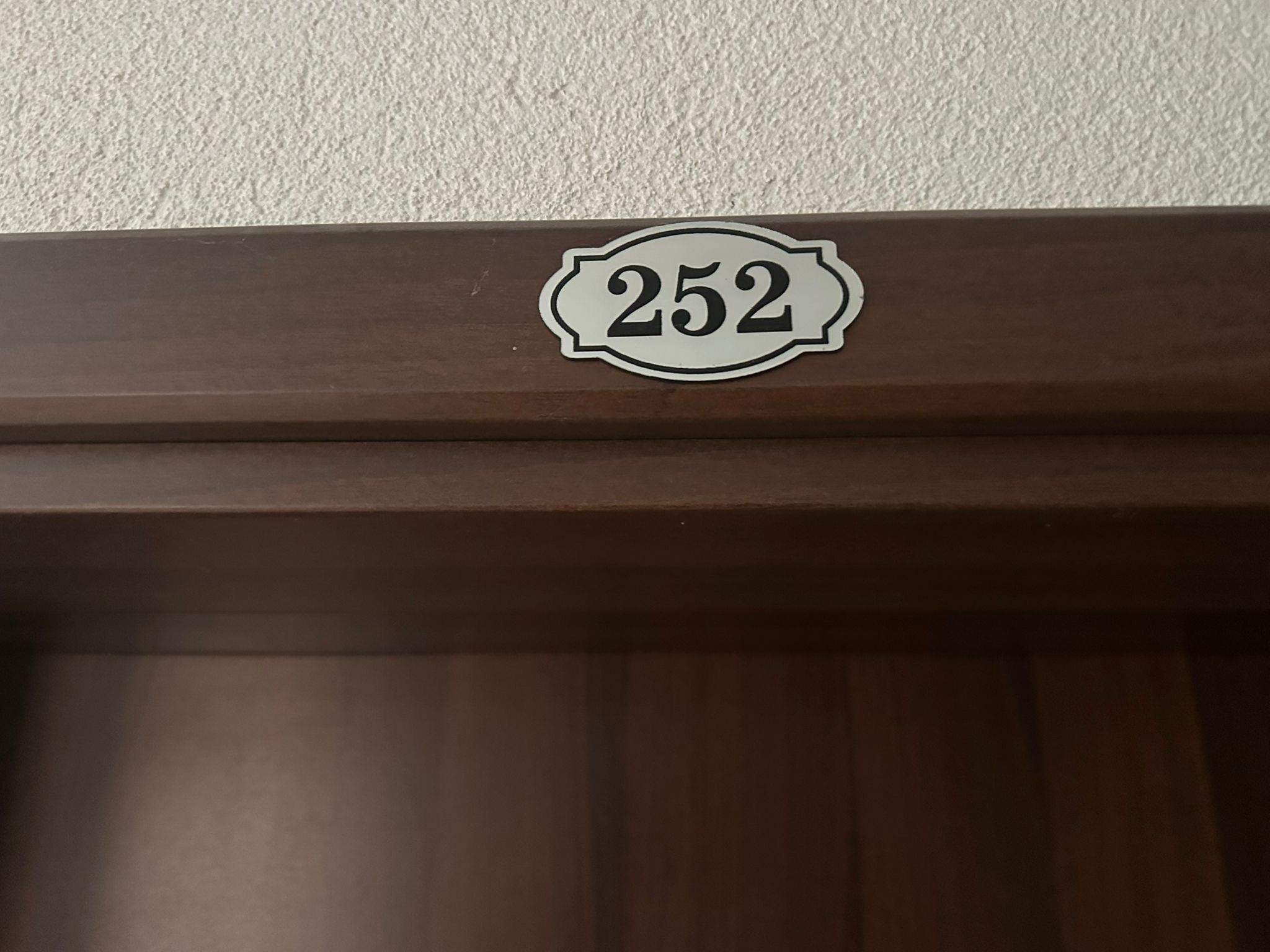 Puerta con una placa que indica el número 252 en un marco marrón.
