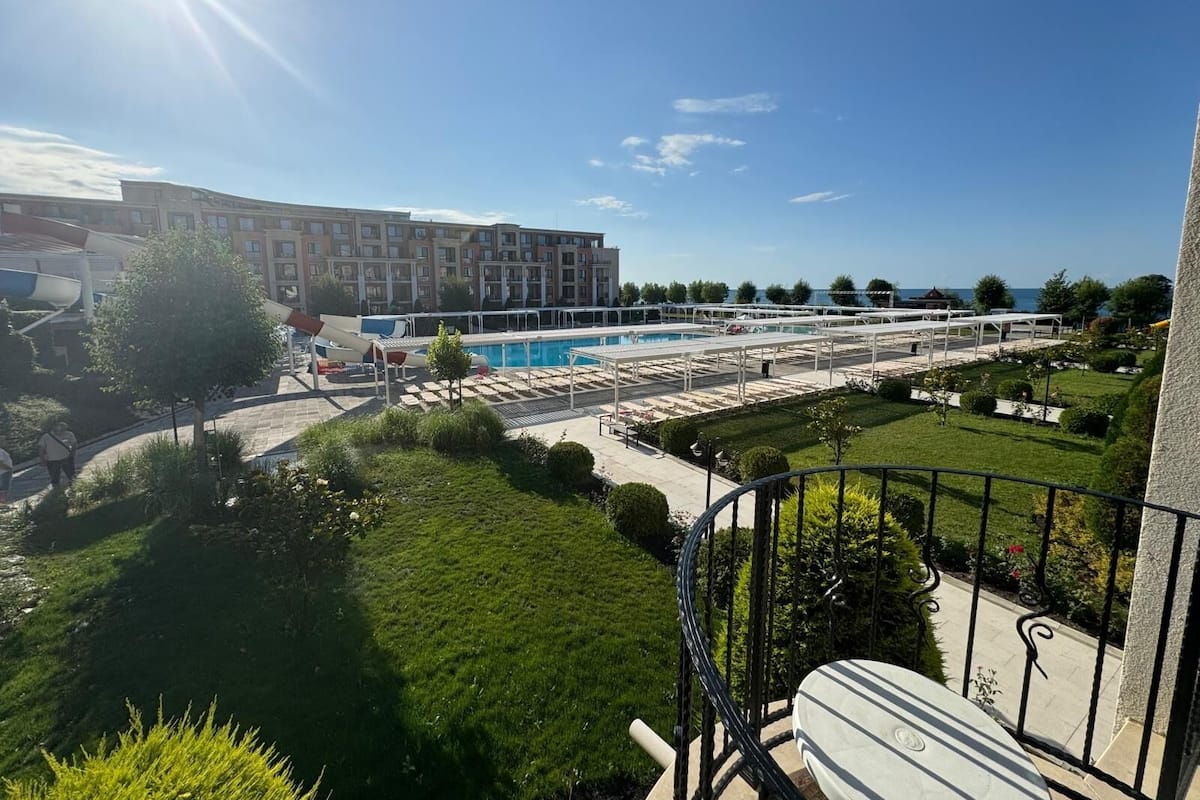 A pool area with a view of a building and a clear sky.