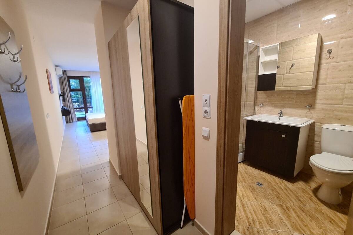 A modern bathroom with a sink, toilet, and mirror.